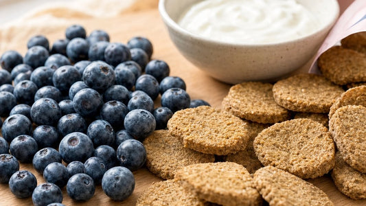Fresh blueberries and Macy Cakes Pup Chips clean-ingredient dog treats on a light wood board